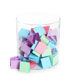 Photo of Many colorful paper pieces in glass isolated on white
