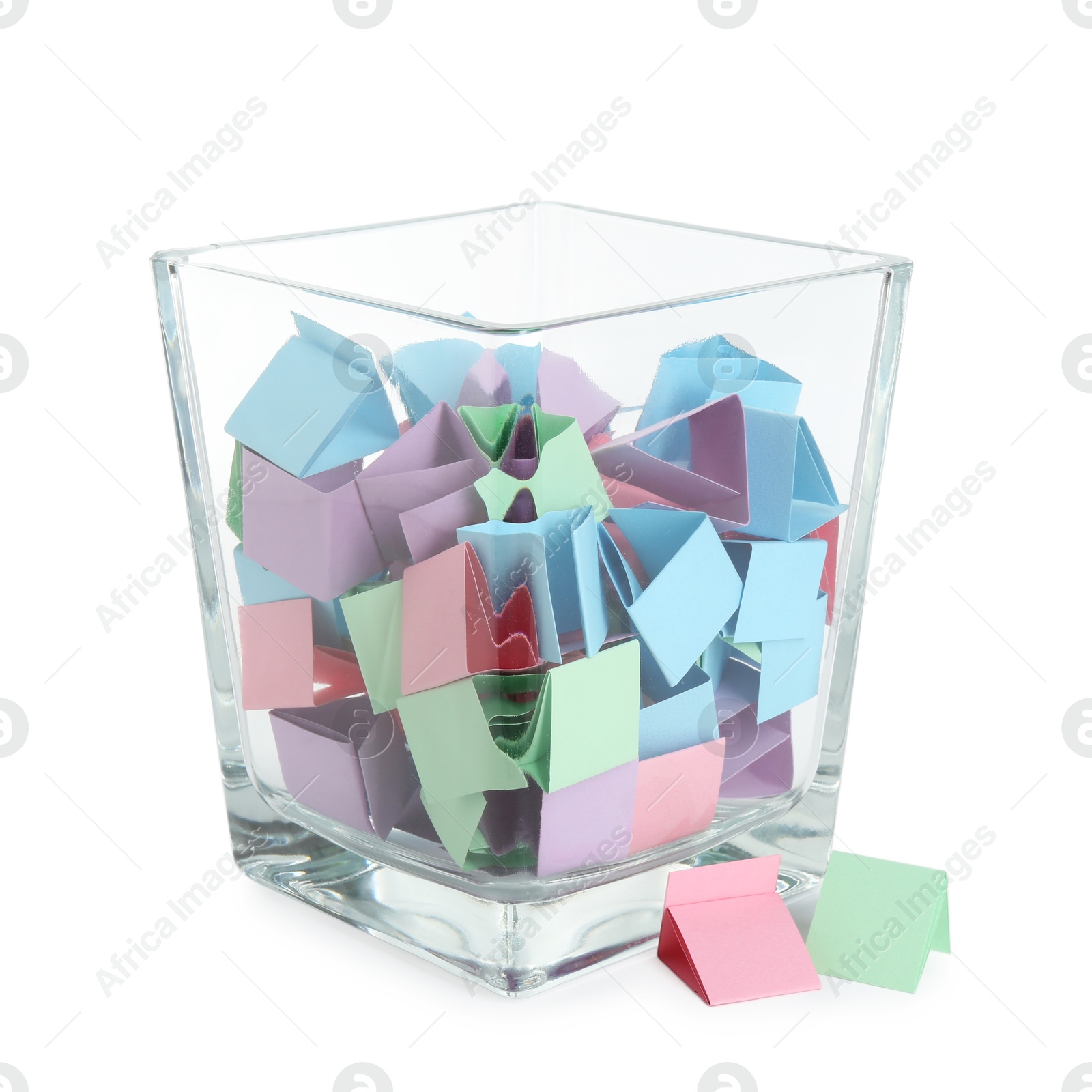 Many colorful paper pieces in glass isolated on white Photo of Many colorful paper pieces in glass isolated on white