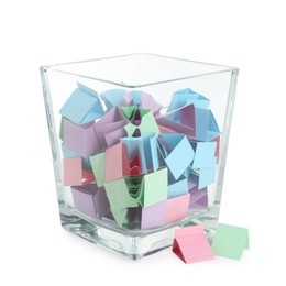 Photo of Many colorful paper pieces in glass isolated on white