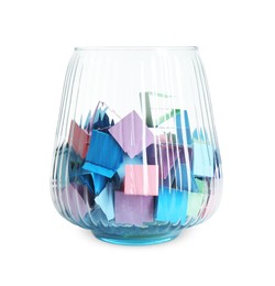 Photo of Many colorful paper pieces in glass isolated on white