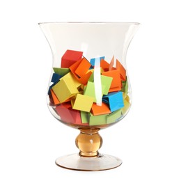 Photo of Many colorful paper pieces in glass isolated on white