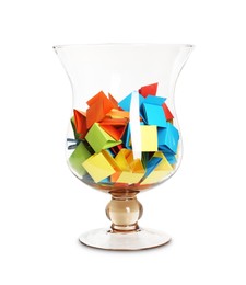 Photo of Many colorful paper pieces in glass isolated on white