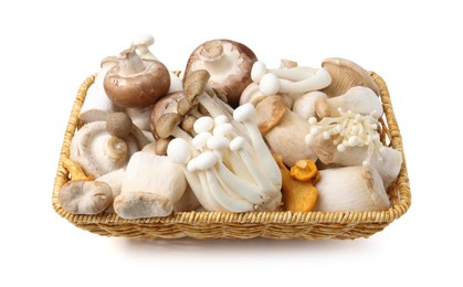 Photo of Different raw mushrooms in wicker basket isolated on white