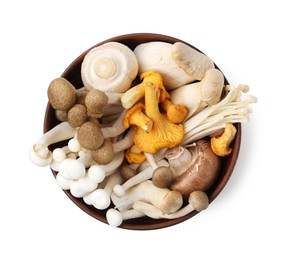 Photo of Different raw mushrooms in bowl isolated on white, top view
