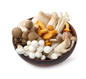 Photo of Different raw mushrooms in wooden bowl isolated on white