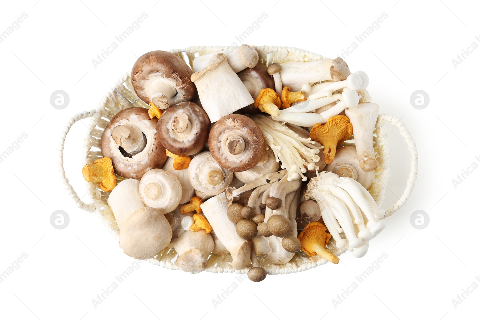 Photo of Different raw mushrooms in wicker basket isolated on white, top view