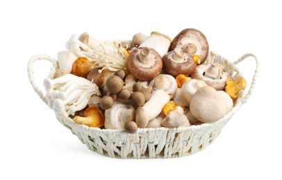Photo of Different raw mushrooms in wicker basket isolated on white