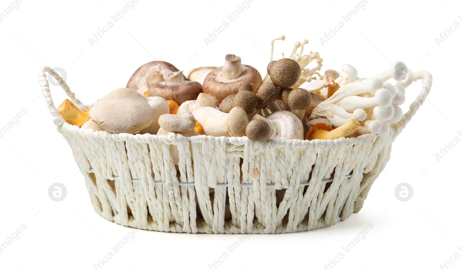 Photo of Different raw mushrooms in wicker basket isolated on white