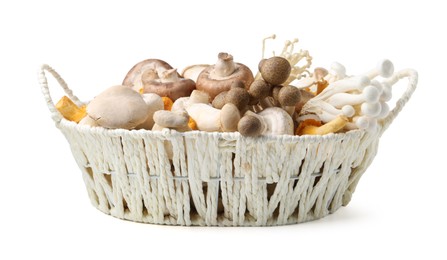 Photo of Different raw mushrooms in wicker basket isolated on white