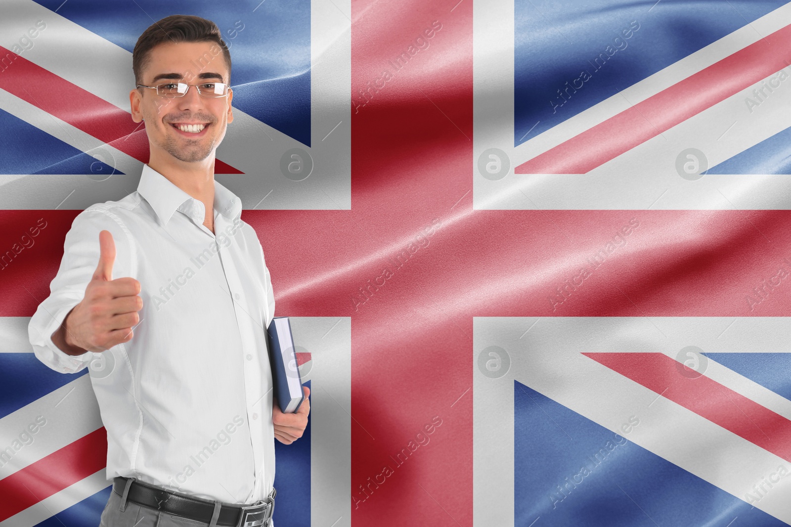 Teacher with book showing thumbs-up against flag of United Kingdom. Language school Image of Teacher with book showing thumbs-up against flag of United Kingdom. Language school