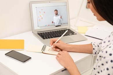 Image of E-learning concept. Student having online video chat with teacher via laptop at desk, closeup