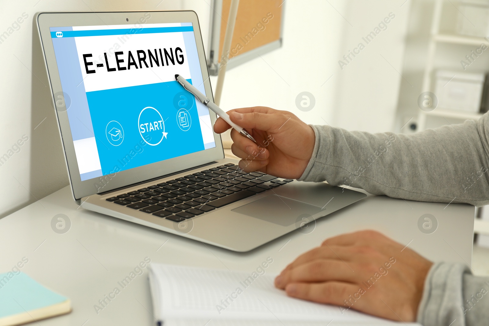 Image of E-learning concept. Man studying online using laptop at desk, closeup