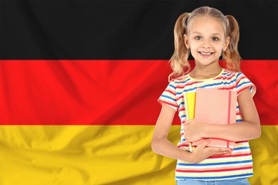 Image of Little girl with notebooks against flag of Germany. Language school