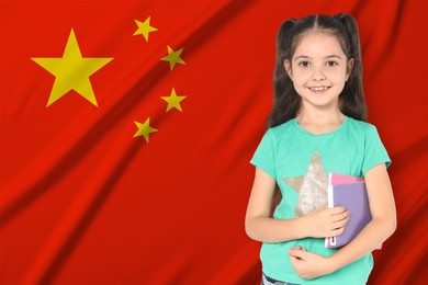 Image of Little girl with notebooks against flag of China. Language school