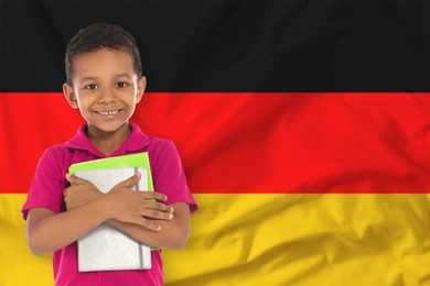 Image of Little boy with notebooks against flag of Germany. Language school