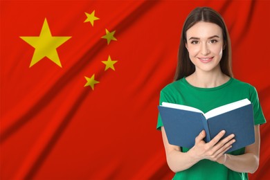 Image of Teacher or student with book against flag of China. Language school