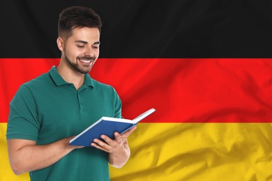 Image of Teacher or student with book against flag of Germany. Language school