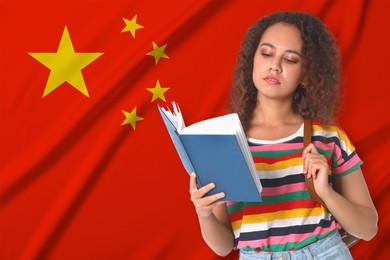 Image of Student with book against flag of China. Language school