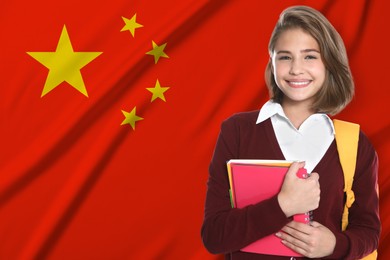 Image of Student with backpack and notebooks against flag of China. Language school