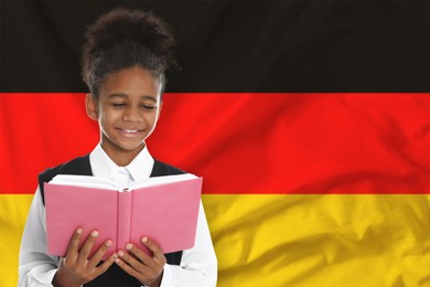 Image of Little girl with book against flag of Germany. Language school