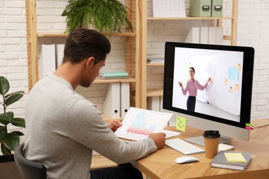 Image of E-learning concept. Student having online video chat with teacher via computer at desk
