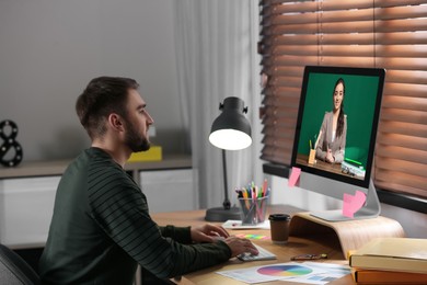 Image of E-learning concept. Student having online video chat with teacher via computer at desk