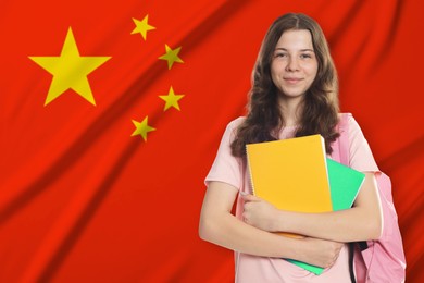 Image of Student with notebooks and backpack against flag of China. Language school