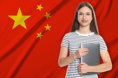 Image of Student with laptop against flag of China. Language school