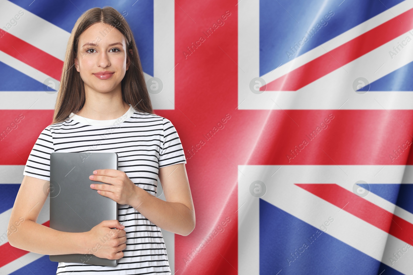 Student with laptop against flag of United Kingdom. Language school Image of Student with laptop against flag of United Kingdom. Language school