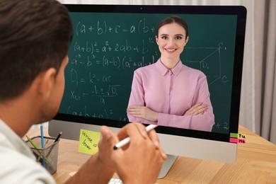 Image of E-learning concept. Student having online video chat with teacher via computer at desk, closeup