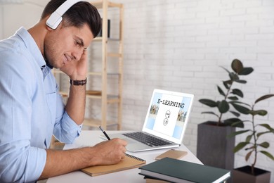 Image of E-learning concept. Man studying online using laptop at desk