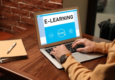 Image of E-learning concept. Man studying online using laptop at desk, closeup