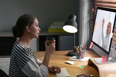 Image of E-learning concept. Student having online video chat with teacher via computer at desk