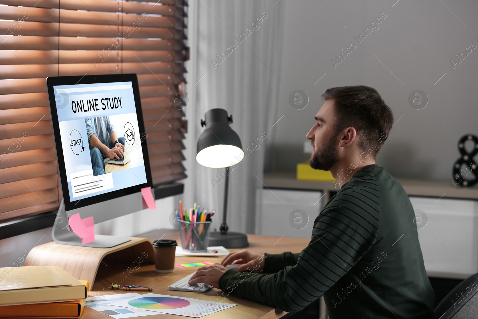 Image of Online study. Man using computer for e-learning at desk