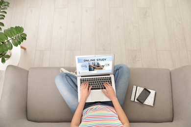 Image of Online study. Woman using laptop for e-learning on sofa at home, top view