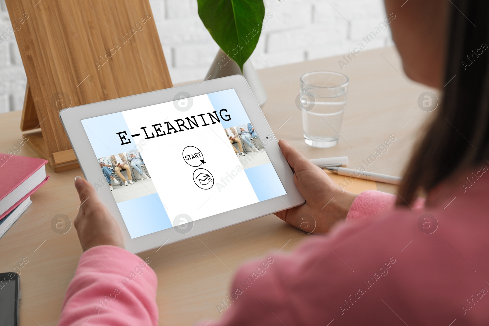 Image of E-learning concept. Woman studying online using tablet computer at desk, closeup