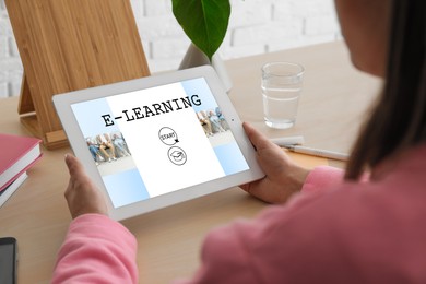 Image of E-learning concept. Woman studying online using tablet computer at desk, closeup