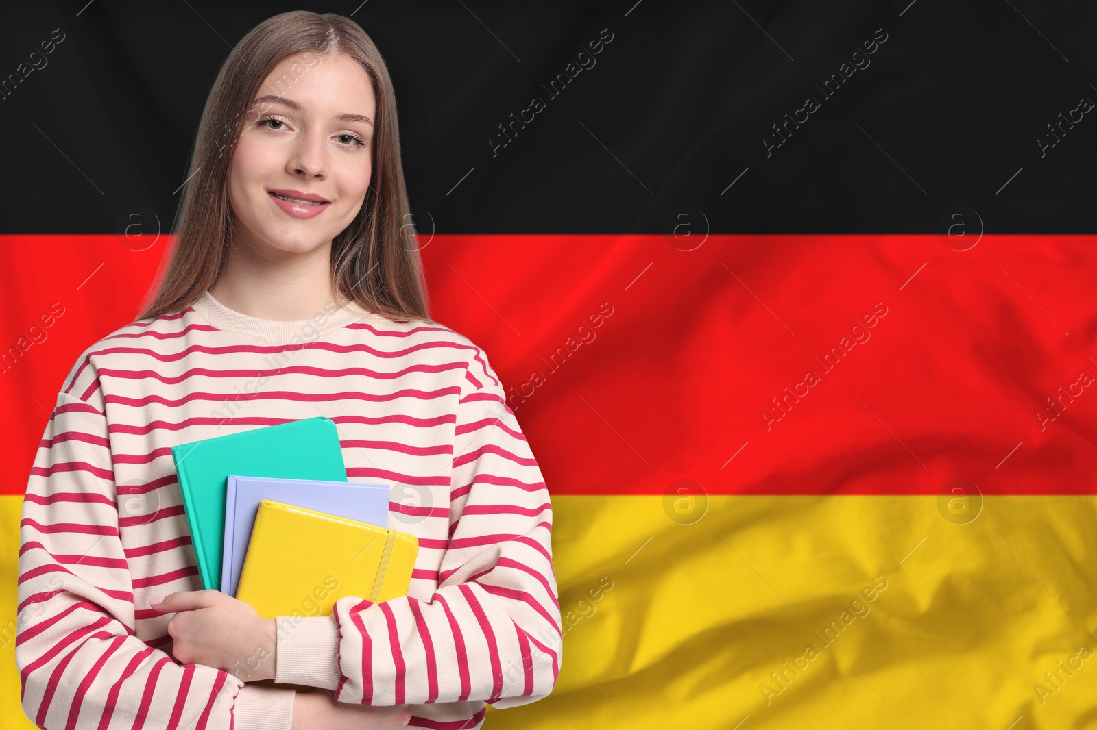 Student with notebooks against flag of Germany. Language school Image of Student with notebooks against flag of Germany. Language school