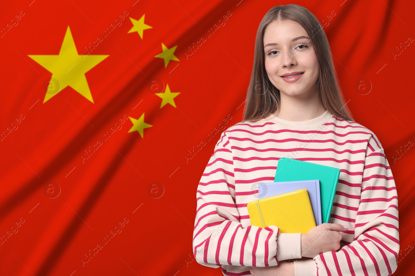 Student with notebooks against flag of China. Language school Image of Student with notebooks against flag of China. Language school