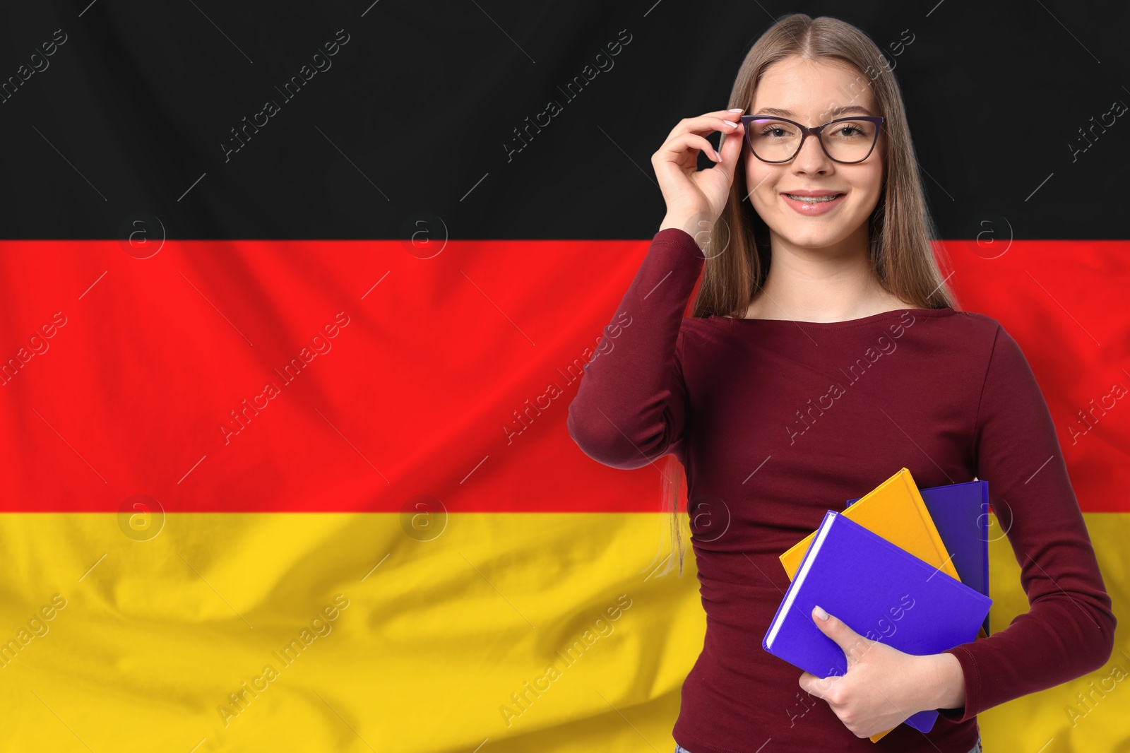 Student with notebooks against flag of Germany. Language school Image of Student with notebooks against flag of Germany. Language school