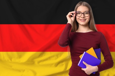 Image of Student with notebooks against flag of Germany. Language school