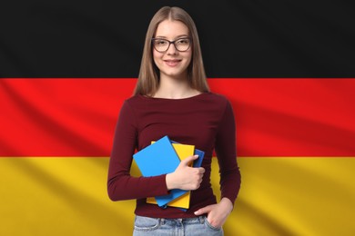 Image of Student with notebooks against flag of Germany. Language school