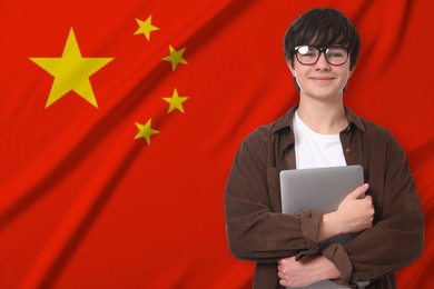 Image of Student with laptop against flag of China. Language school