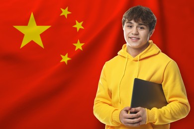 Image of Student with laptop against flag of China. Language school
