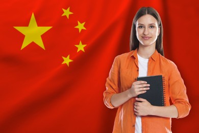 Image of Student with notebook against flag of China. Language school