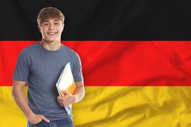 Image of Student with notebooks against flag of Germany. Language school