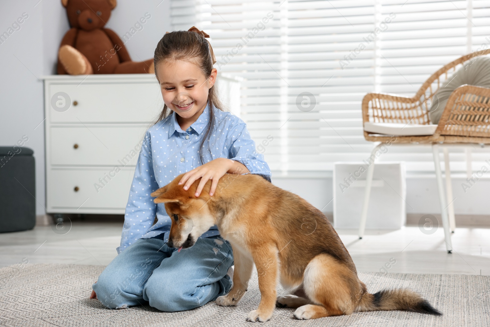 Smiling little girl with her dog on floor at home. Child and pet Photo of Smiling little girl with her dog on floor at home. Child and pet