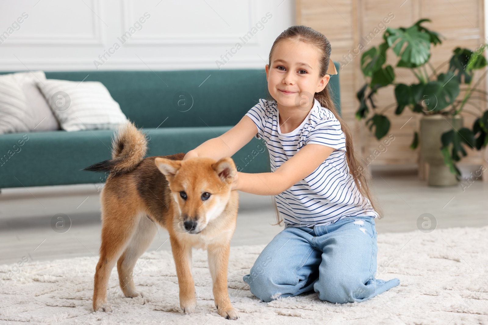 Cute little girl with her dog on floor at home. Child and pet Photo of Cute little girl with her dog on floor at home. Child and pet