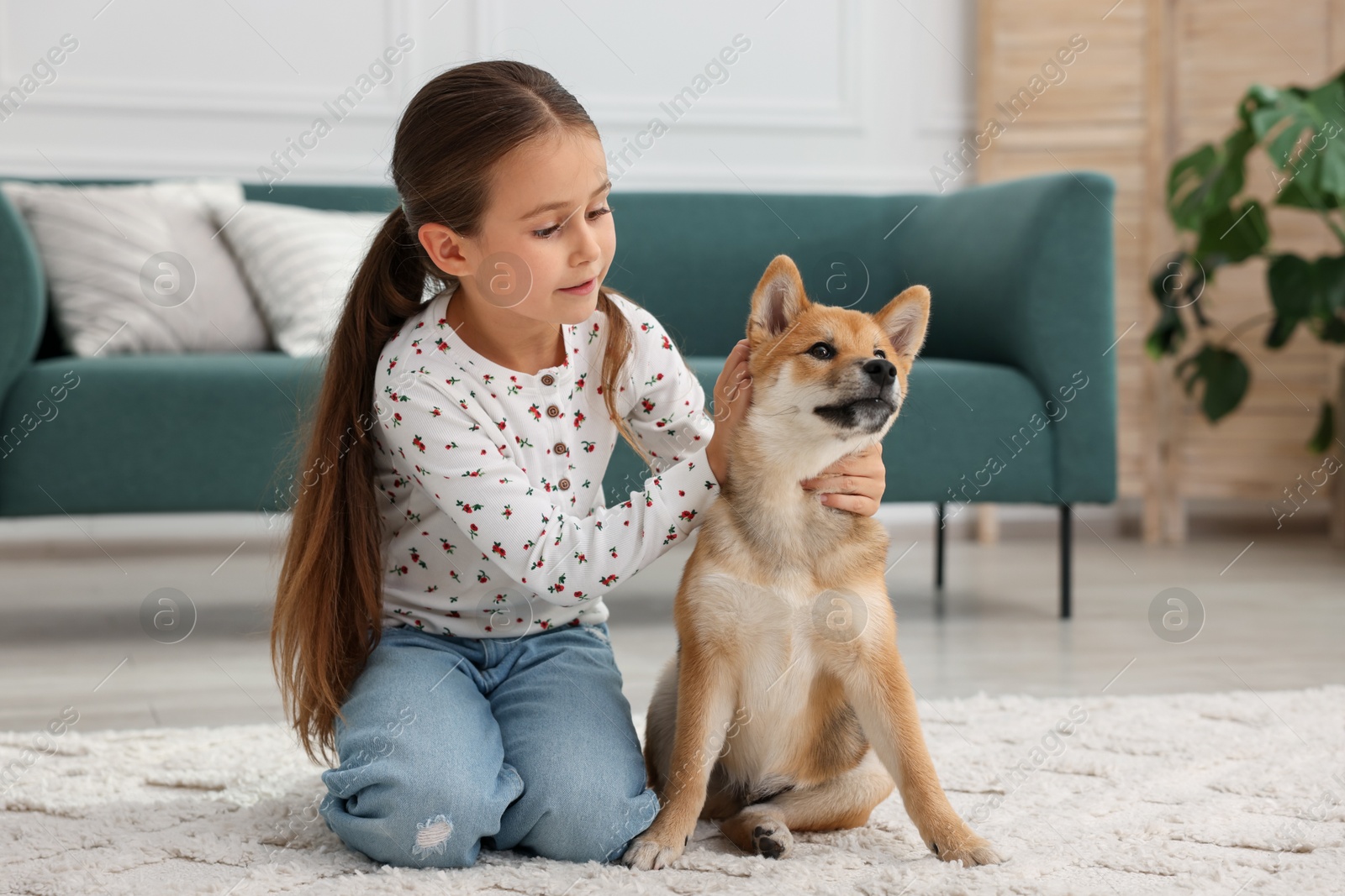 Cute little girl with her dog on floor at home. Child and pet Photo of Cute little girl with her dog on floor at home. Child and pet