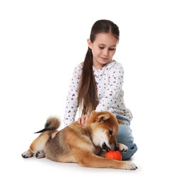 Photo of Cute little girl and her dog with pet toy on white background